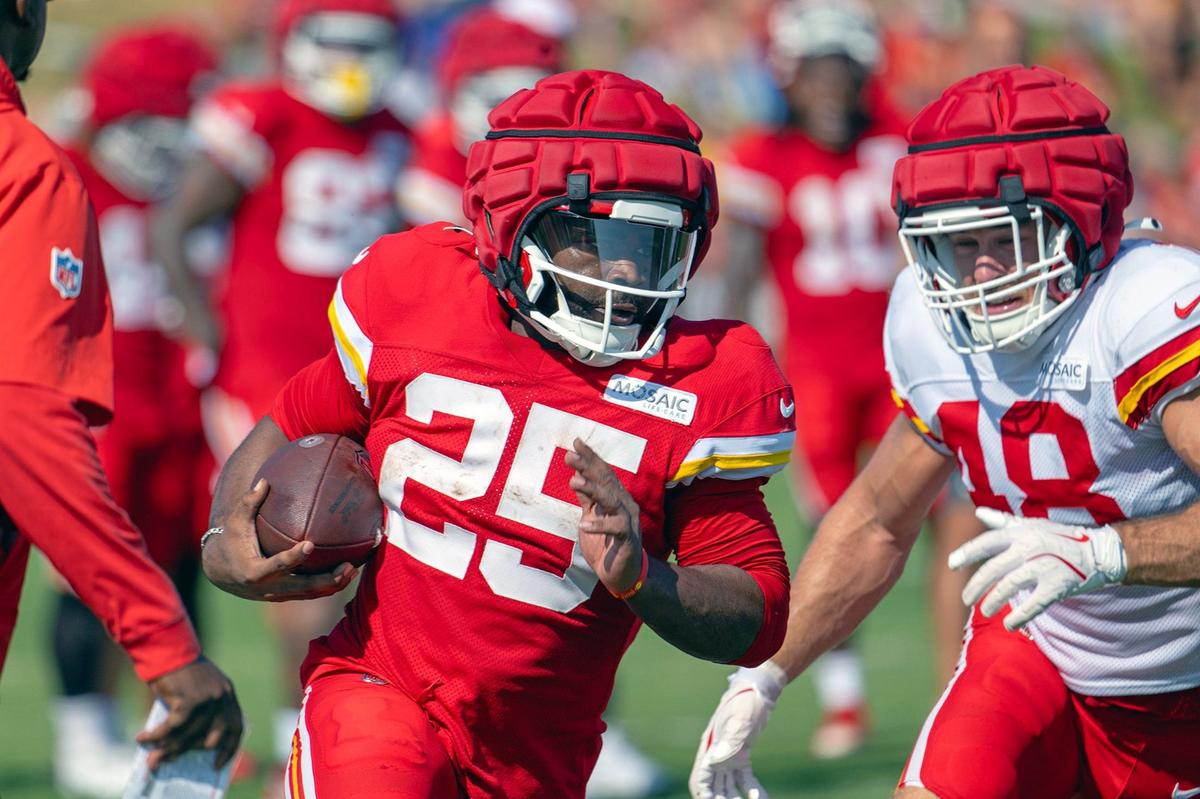 Chiefs running back Clyde Edwards-Helaire (25) runs with a handoff past linebacker Cole Christiansen (48) during training camp at Missouri Western State University on Thursday, Aug. 1, 2024, in St. Joseph.