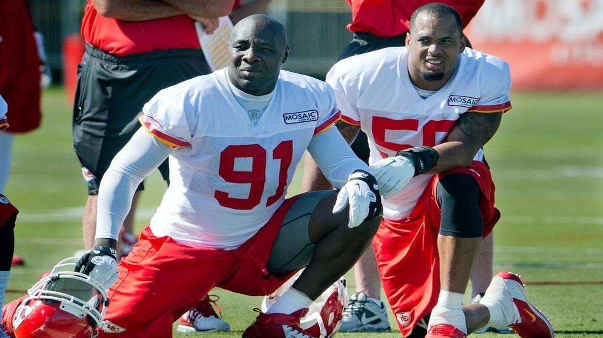 Tamba Hali (left), who’d signed a new contract of his own earlier in the week, was at the front of the line of friends and teammates urging Derrick Johnson (right) to remain in Kansas City.
