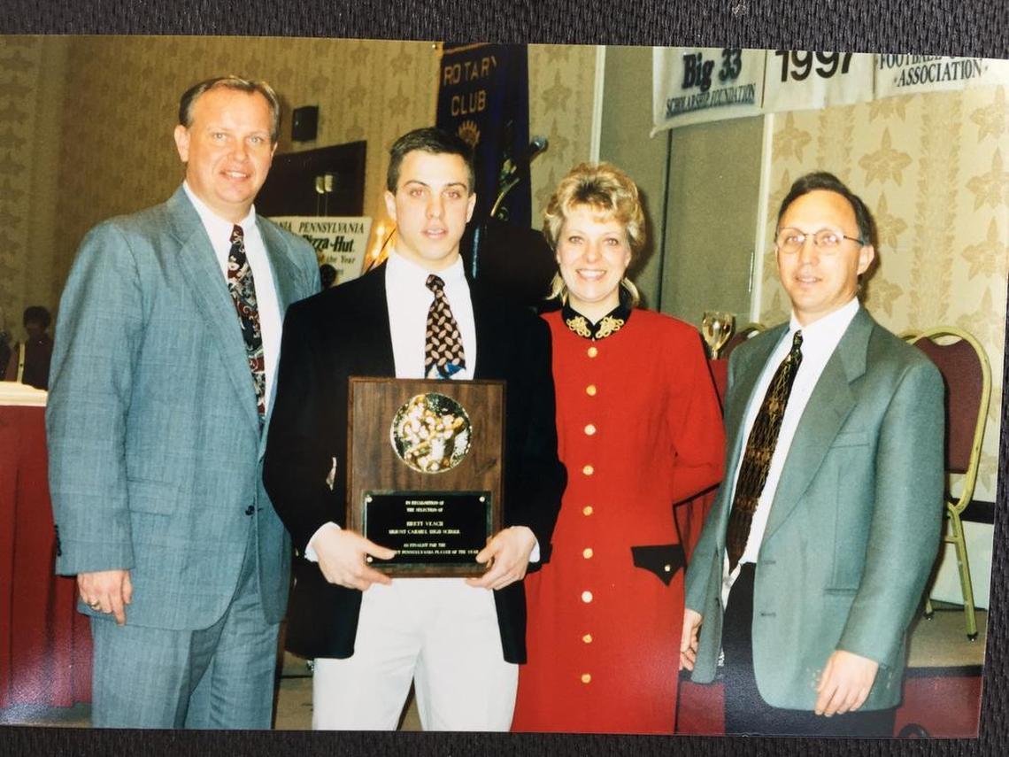 Brett Veach (second from left) holds his 1996 Associated Press Pennsylvania Small School Player of the Year Award with his high school coach, Dave “Whitey” Williams (far left) and his parents, Donna and Bob Veach.