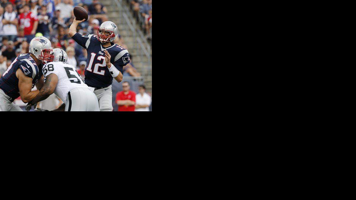 New England Patriots quarterback Tom Brady looks for a receiver over Oakland Raiders defensive end LaMarr Woodley (58) in the first half of an NFL football game, Sunday, Sept. 21, 2014, in Foxborough, Mass.