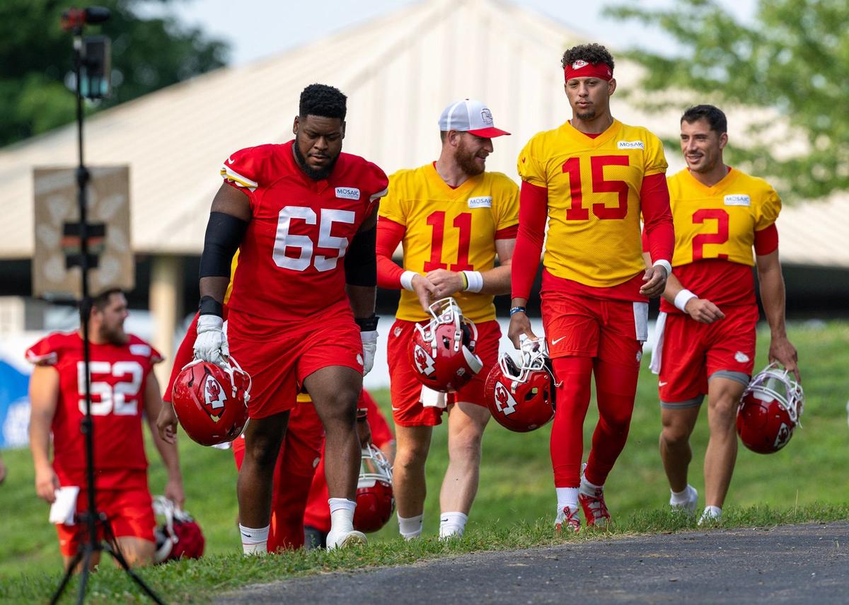 Chiefs guard Trey Smith (65), quarterbacks Carson Wentz (11) and Patrick Mahomes (15) and Ian Book (2) walk to the field for training camp at Missouri Western State University on Tuesday, July 23, 2024, in St. Joseph.
