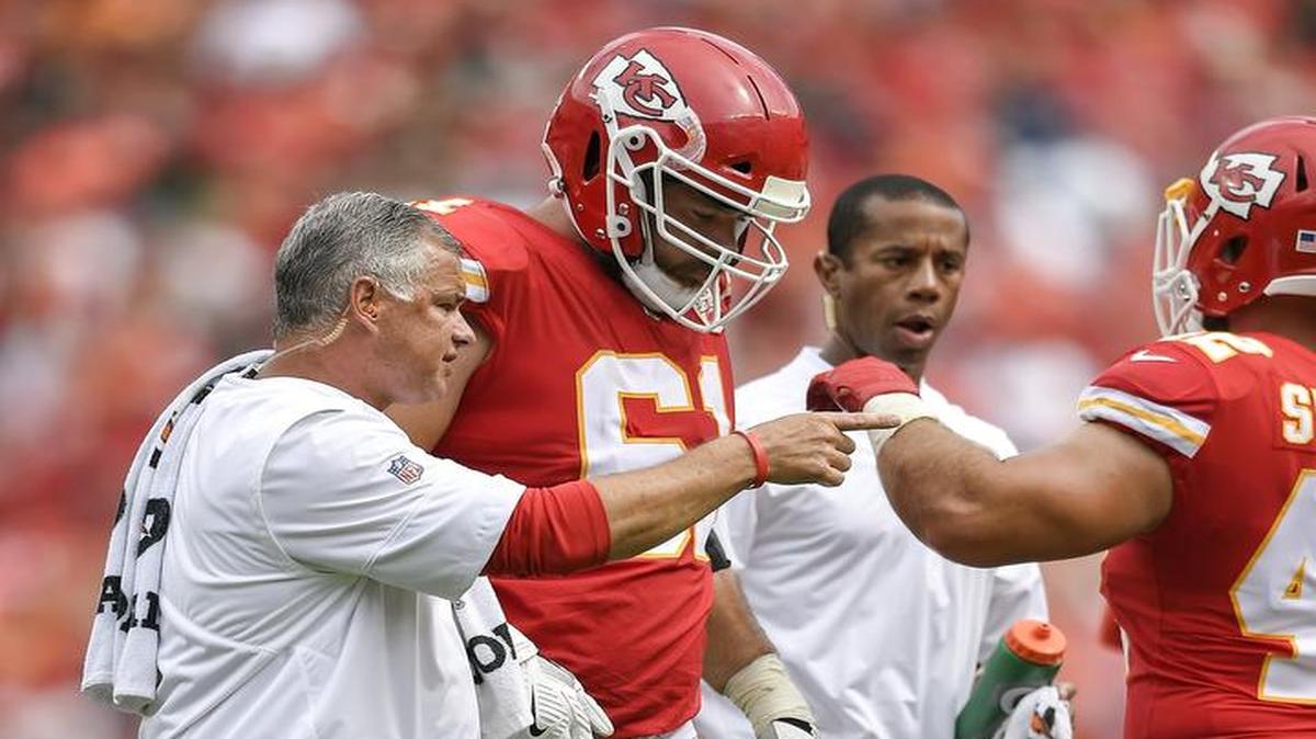 Chiefs center Mitch Morse was assisted off the field by head athletic trainer Rick Burkholder (left) after Morse sprained his foot against the Eagles on Sunday at Arrowhead Stadium. Test results showed that Morse does not need surgery.