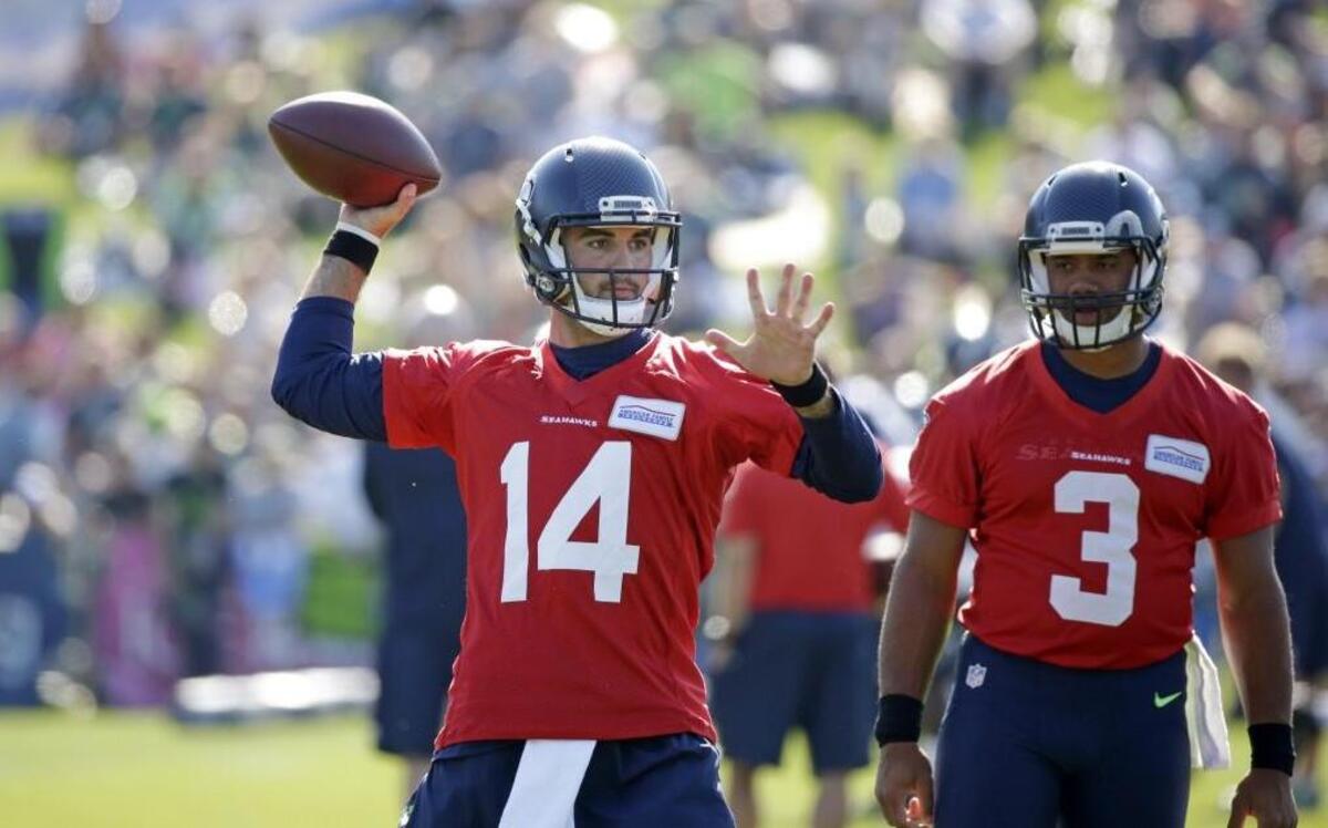 
Jake Waters (left) threw a pass during training camp last week while Russell Wilson watched.

