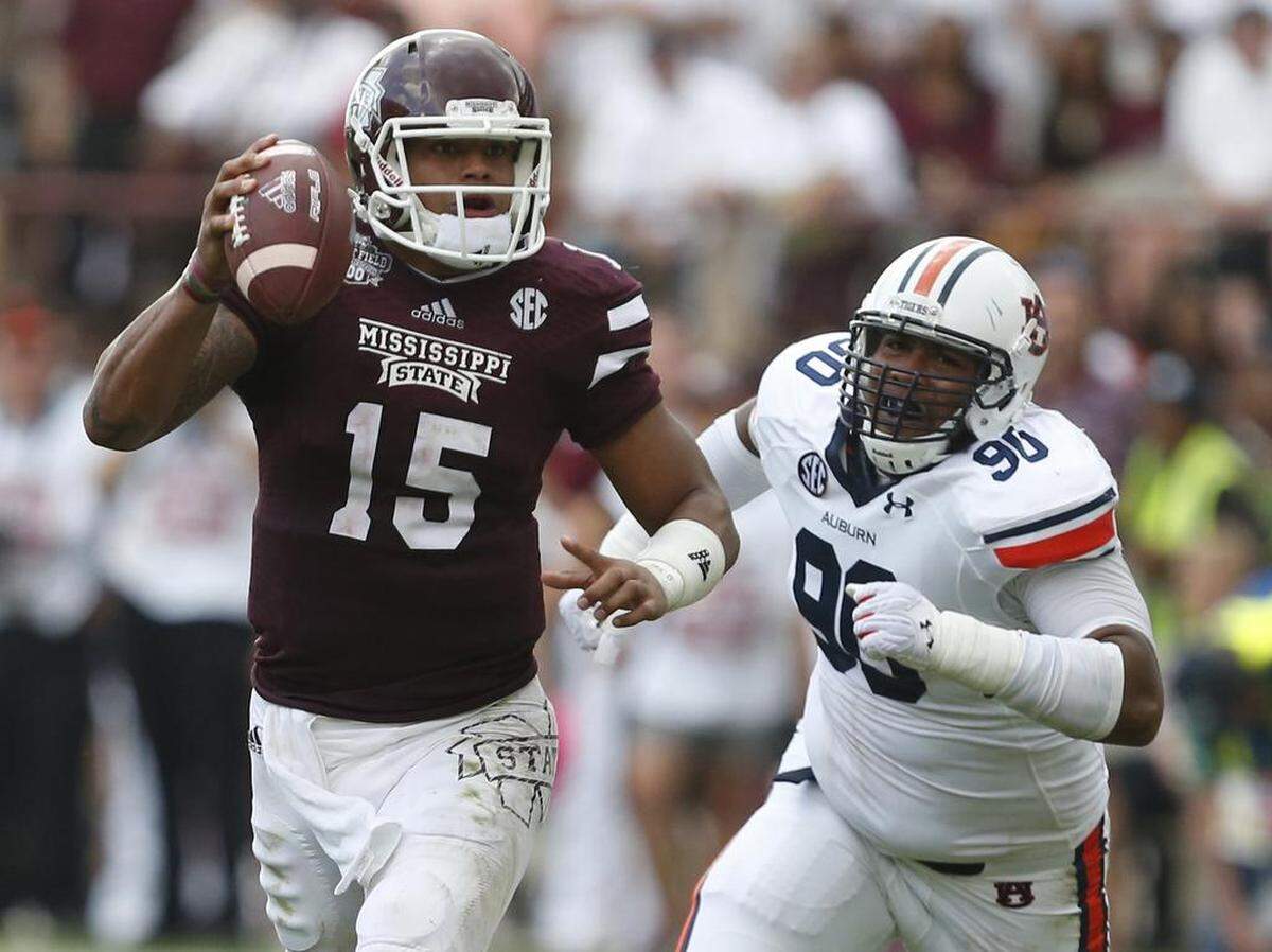 Mississippi State quarterback Dak Prescott was pursued by Auburn defensive lineman Gabe Wright on Saturday, Oct. 11, 2014 in Starkville, Miss.