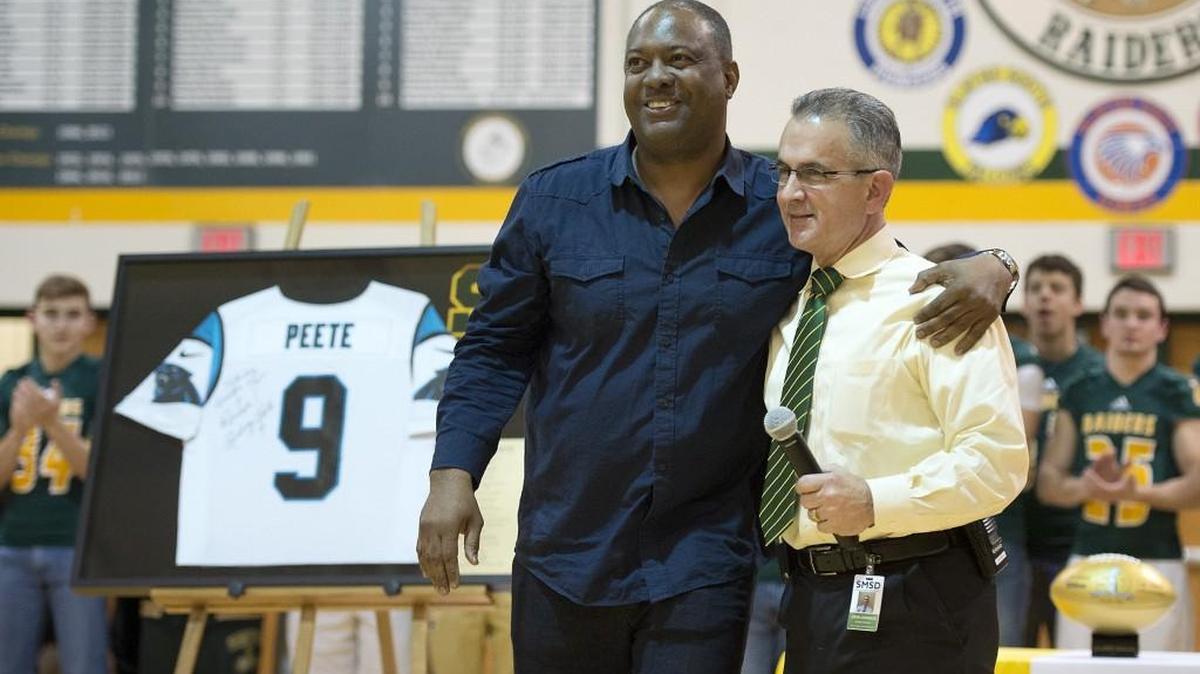 Former NFL player Rodney Peete (left) gave a commemorative football and a jersey to SM South athletic director John Johnson on Tuesday.