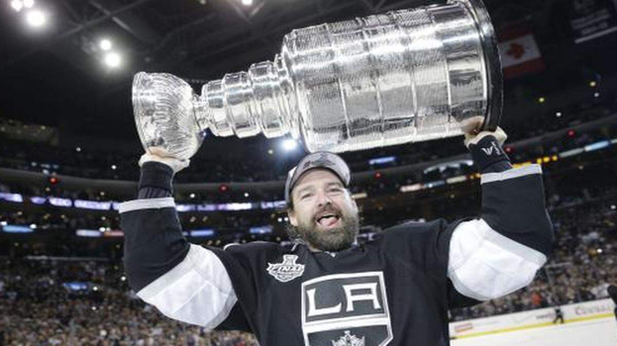 
Kings right wing Justin Williams hoists the Stanley Cup after Los Angeles beat the New York Rangers in double overtime to with the NHL championship.
