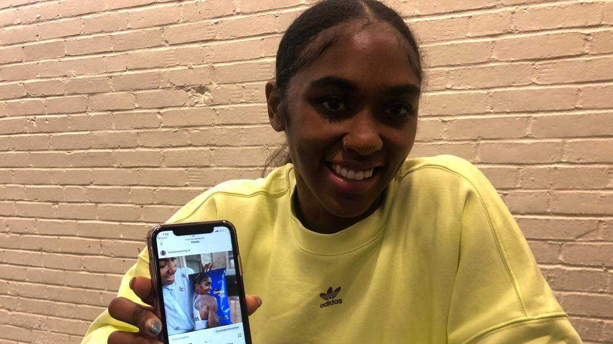 US Olympian Christina Clemons holds up a photo of herself on the cover of a bag of Doritos. Clemons, who will compete for Team USA in the 100-meter hurdles, gained widespread fame after she wore Cool Ranch Doritos earrings at the US Track and Field trials.