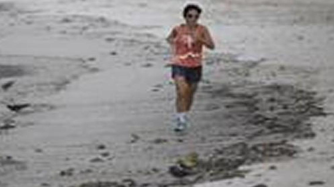 A woman ran next to the trash Saturday that littered the Botafogo beach next to Sugar Loaf mountain and Guanabara Bay in Rio de Janeiro, Brazil. An Associated Press investigation has found the waters where Olympians will compete in swimming and boating events next summer in South America's first games are rife with human sewage and present a serious health risk for athletes.