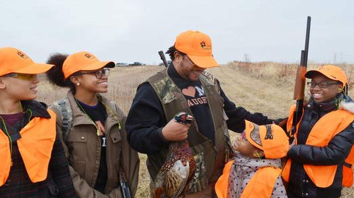 Sommari Muwwakkil celebrated with his daughters Eshante (from left), Inkera, Sommyia and Mikhia after shooting a pheasant last weekend at the Harding Gamebirds hunting preserve in northern Missouri. They participated in a hunt organized by the Black Wolf Hunting Club to introduce more blacks to hunting.