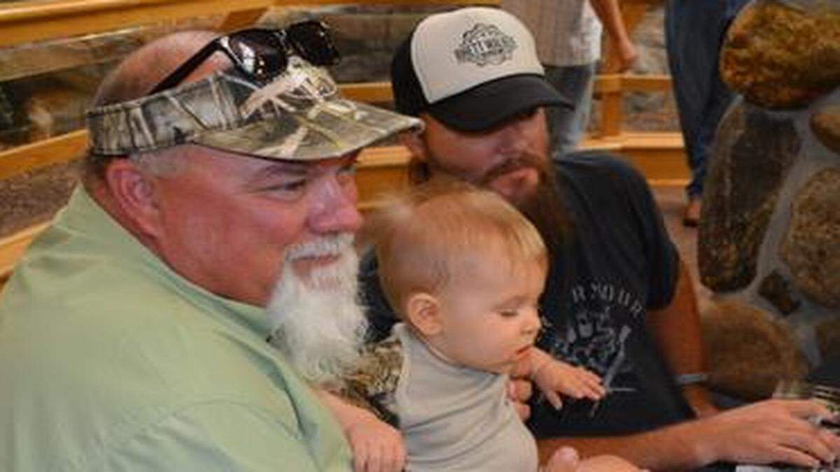 
John Godwin (left) and Jay Stone of “Duck Dynasty” greeted their fans last weekend at Cabela’s store in Kansas City, Kan. While signing autographs, they posed for a photo with eight-month-old Henry Pace. “He (her son) even wore his camouflage shirt for you,” said Renee Pace, Henry’s mom.
