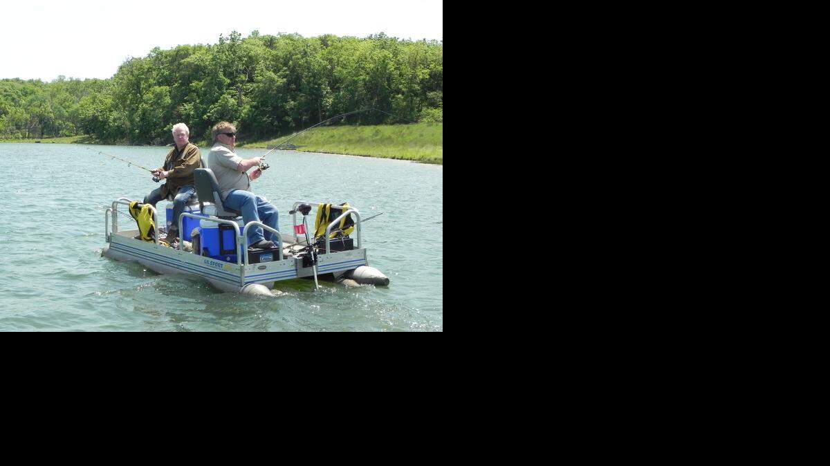 
Joe Bisogno (right) fought a bass on the lake at his Timber Hills Lake Ranch as his friend, Gary Regan, looked on. 
