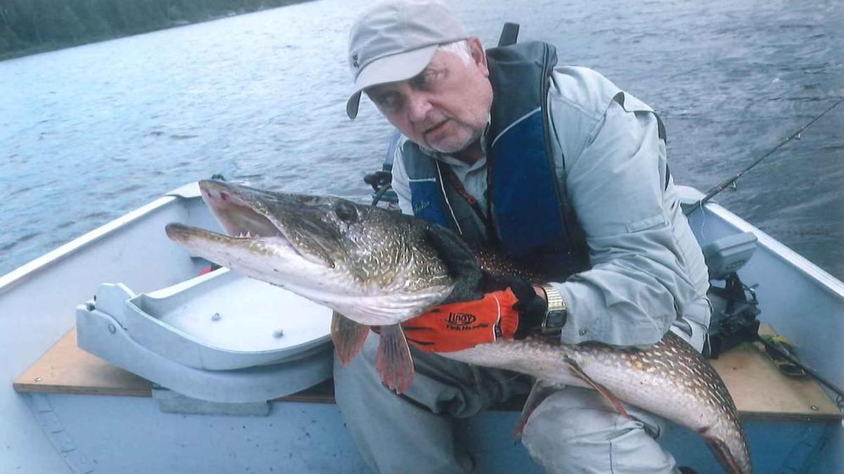 Bob Bates of Prairie Village hugged the 56-inch northern pike he caught last week in Ontario, Canada. He later released the fish.