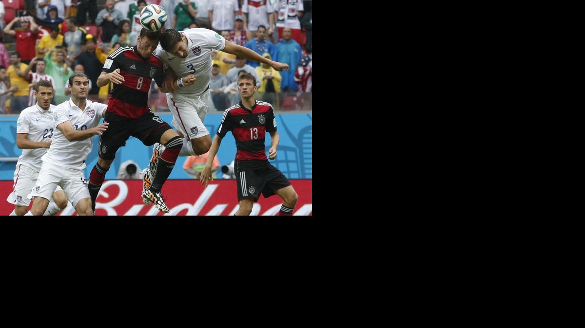 
Germany's Mesut Ozil, center, goes for a header with United States' Omar Gonzalez as United States' Graham Zusi, left, looks on during the group G World Cup soccer match between the USA and Germany at the Arena Pernambuco in Recife, Brazil, Thursday, June 26, 2014. 
