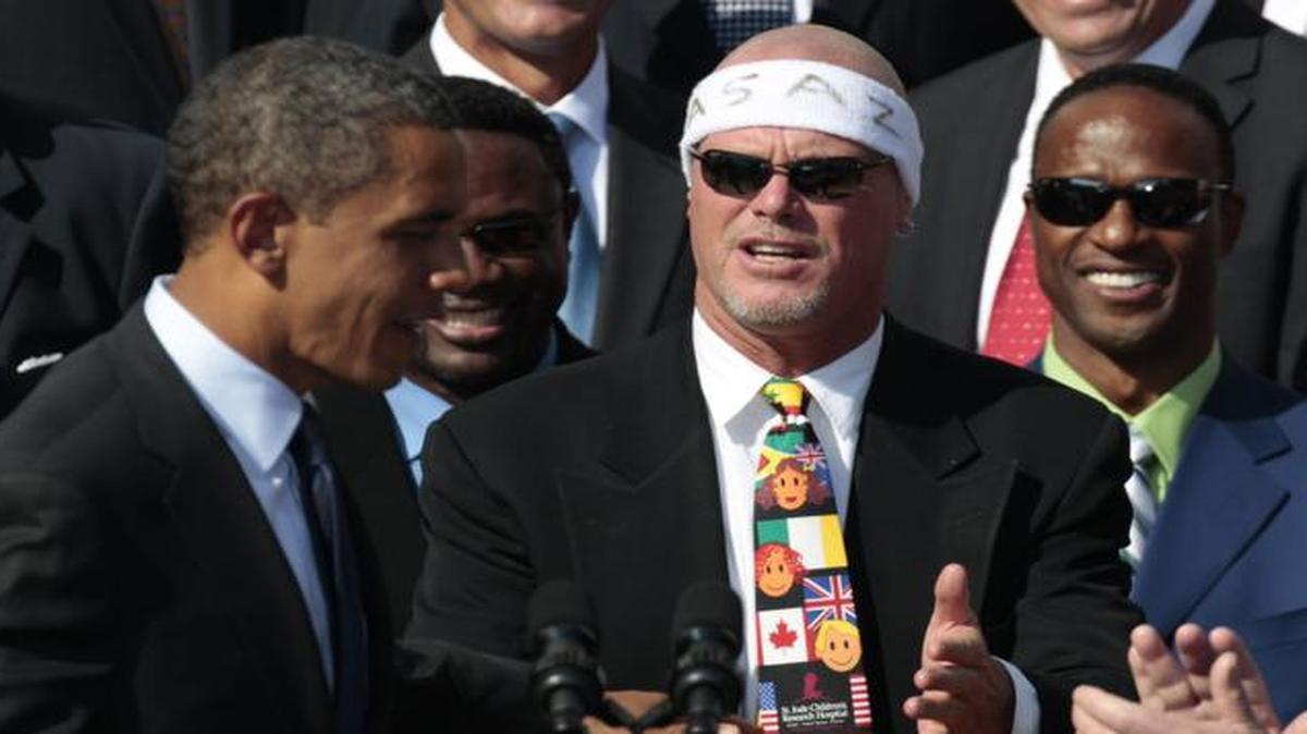 
In this 211 file photo, President Barack Obama, left, looks towards quarterback Jim McMahon, wearing headband, as he honors the 1985 Super Bowl XX Champion Chicago Bears football team during a ceremony on the South Lawn of the White House in Washington. 
