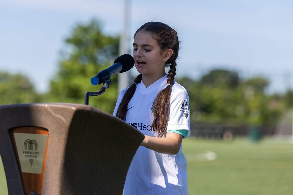 Youth from Estrella De Oro speaks during the opening ceremony of the Kansas City Current's No-Cost, No-Barrier Soccer League at 901 Van Brunt Blvd on Saturday, July 11, 2026. The league, presented by CVS Health, aims to increase youth soccer participation, particularly among girls, while providing education for coaches and referees.