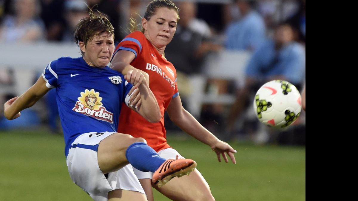 
FCKC's Becca Moros (left) advances the ball past Houston's Kealia Ohai during the second period of Monday night's game at Swope Soccer Village.
