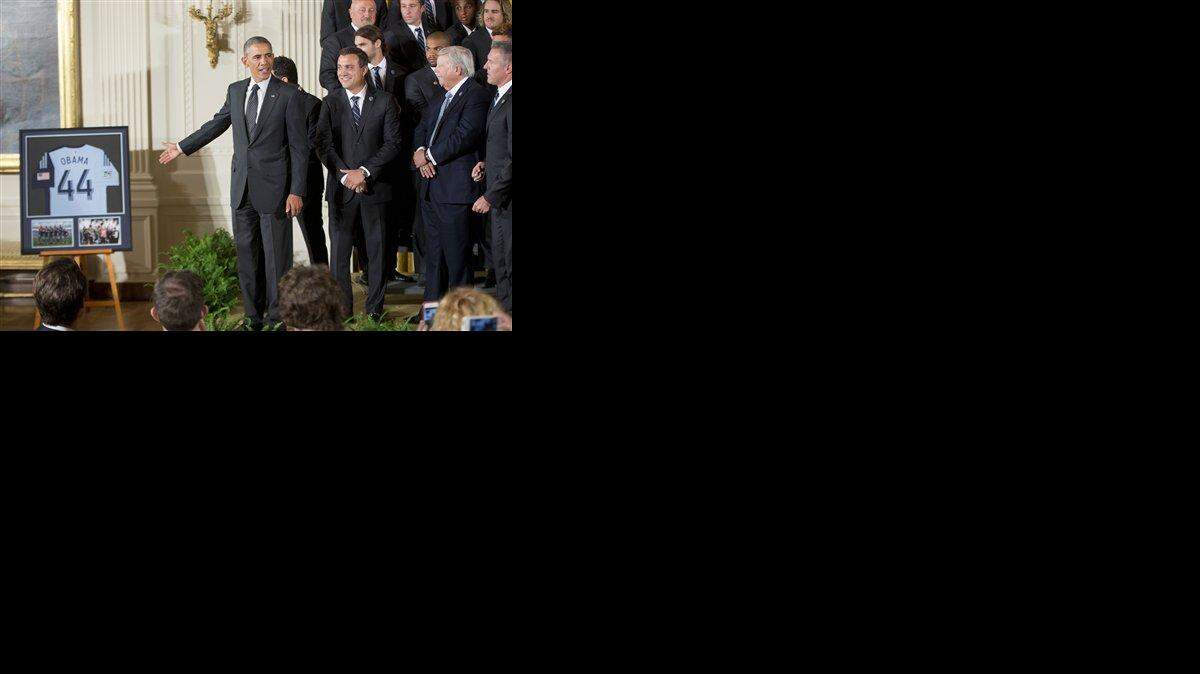 President Barack Obama points to a framed team jersey that was given to him by the members of the Sporting Kansas City soccer team during a ceremony in the East Room of the White House in Washington, Wednesday, Oct. 1, 2014, where he honored the 2013 Major League Soccer champions.