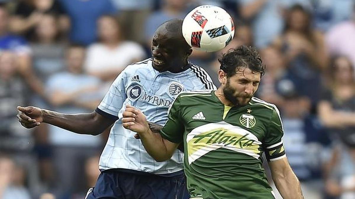 Sporting Kansas City's Lawrence Olum (16) and Portland's Diego Valeri go up for the ball in the second half of a game in July.