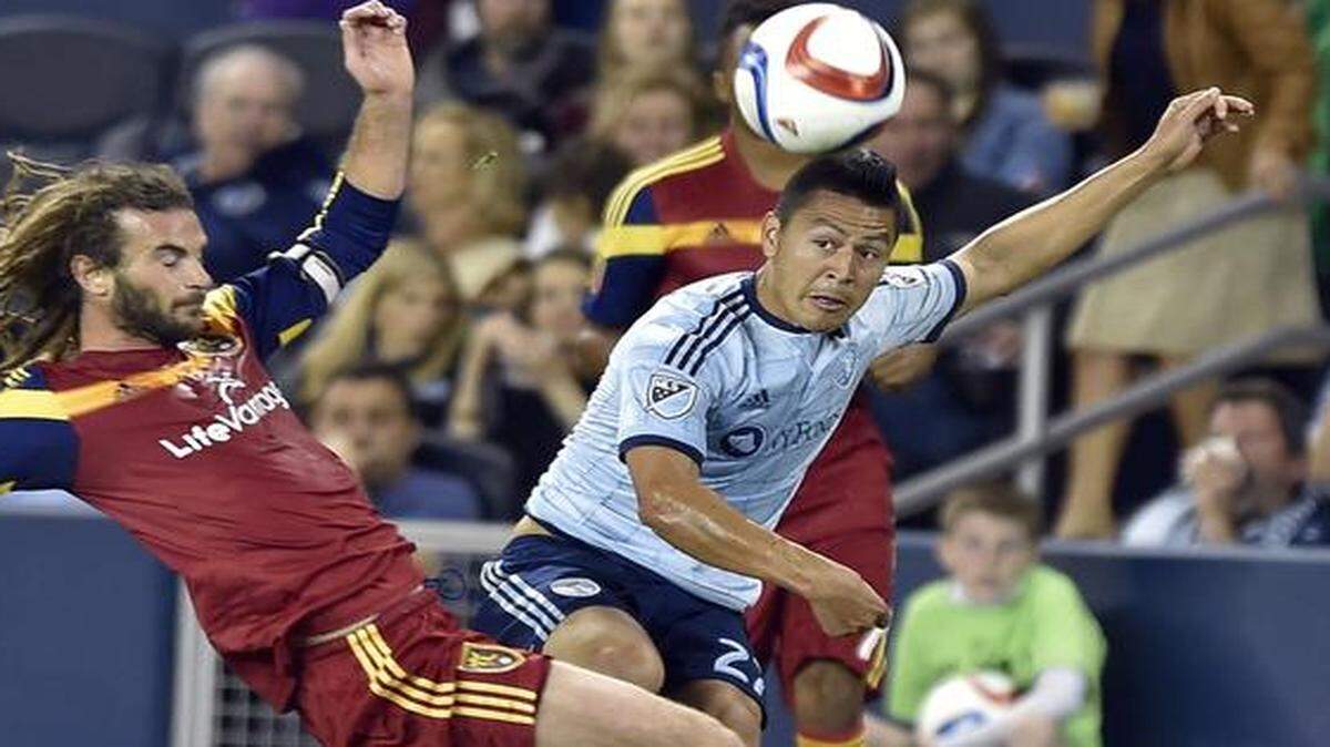 Sporting KC's Roger Espinoza (right) got a pass by Real Salt Lake's Kyle Beckerman during the second half of Saturday night's match at Sporting Park.
