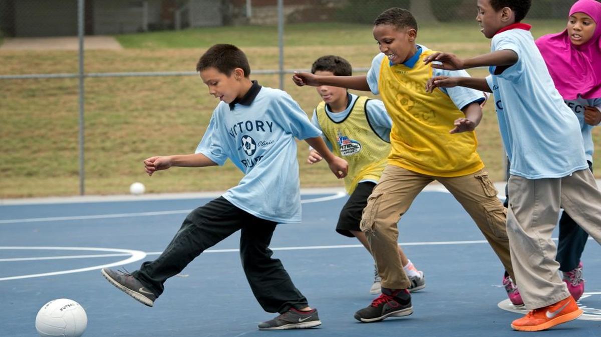 
Students from Welborn Elementary School learned how to play futsal, a variant of soccer, from Sporting KC players and employees on Monday, following a ribbon cutting ceremony for new courts in Welborn Park, 2520 N. 55th Street in Kansas City, Kan. Jose Moreno Jr. (left), 8, had a step on other players as they got to try the sport.
