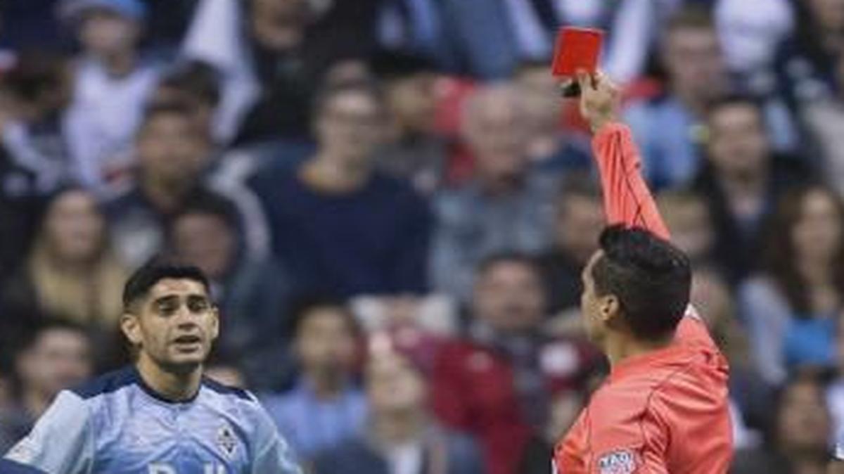 Vancouver’s Matias Laba (second from left) received a red card from referee Jair Marrufo during a game last Saturday.
