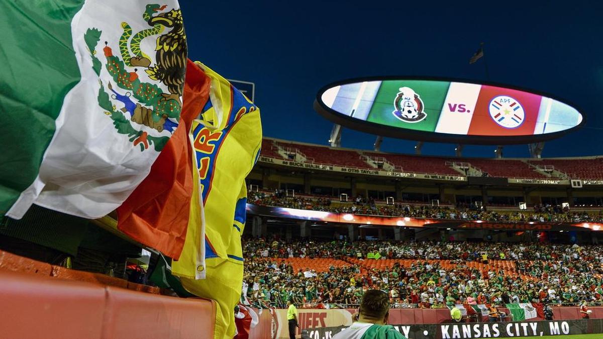 Fans cheer using flags while watching the soccer match between the national teams of Mexico and Paraguay at Arrowhead Stadium on Tuesday, March 31, 2015, in Kansas City.