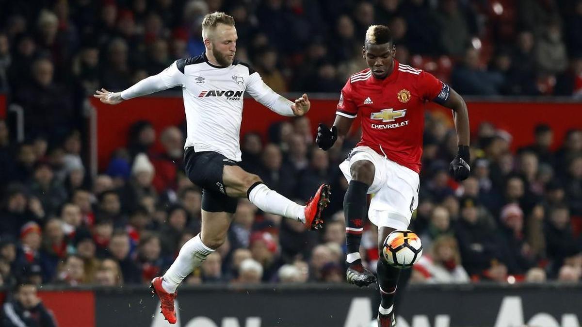 Derby County’s Johnny Russell (left) and Manchester United’s Paul Pogba went for a ball during a third-round FA Cup match at Old Trafford in Manchester, England on Jan. 5.