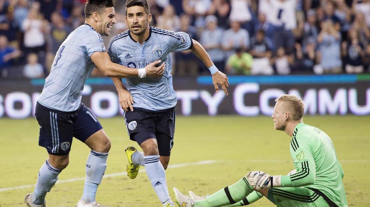 
Sporting KC forward Dom Dwyer (left) celebrated with teammate Sporting KC midfielder Paulo Nagamura after scoring his first goal in the second half against Vancouver FC goalkeeper David Ousted who sat on the ground after the game was tied on Saturday at Sporting Park in Kansas City, Kansas. Sporting won the game 4-3.
