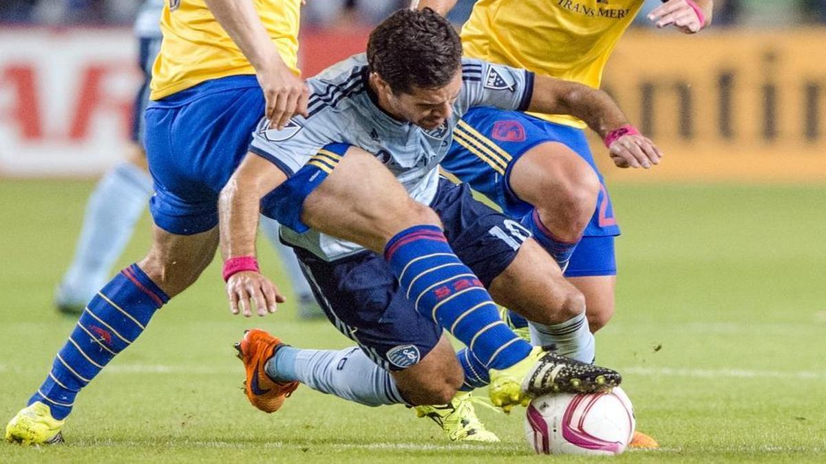 Sporting Kansas City midfielder Benny Feilhaber (10) was sandwiched between Colorado Rapids forward Kevin Doyle (9) and Rapids midfielder Lucas Pittinari (22) in the scoreless first half of the match Wednesday night at Sporting Park.