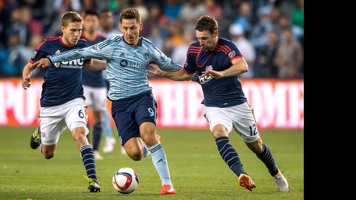 
Sporting KC forward Krisztian Nemeth (9) split the defense of New England Revolution midfielders Scott Caldwell (6) and Andy Dorman (12) in the first half during an MLS match at Sporting Park in Kansas City, Kan. on May 20, 2015.
