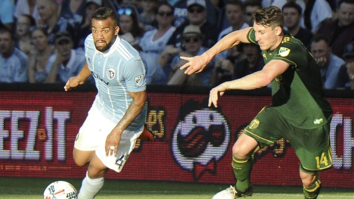 Kevin Ellis dribbles the ball around Portland’s Ben Zemanski during a July game for Sporting Kansas City.