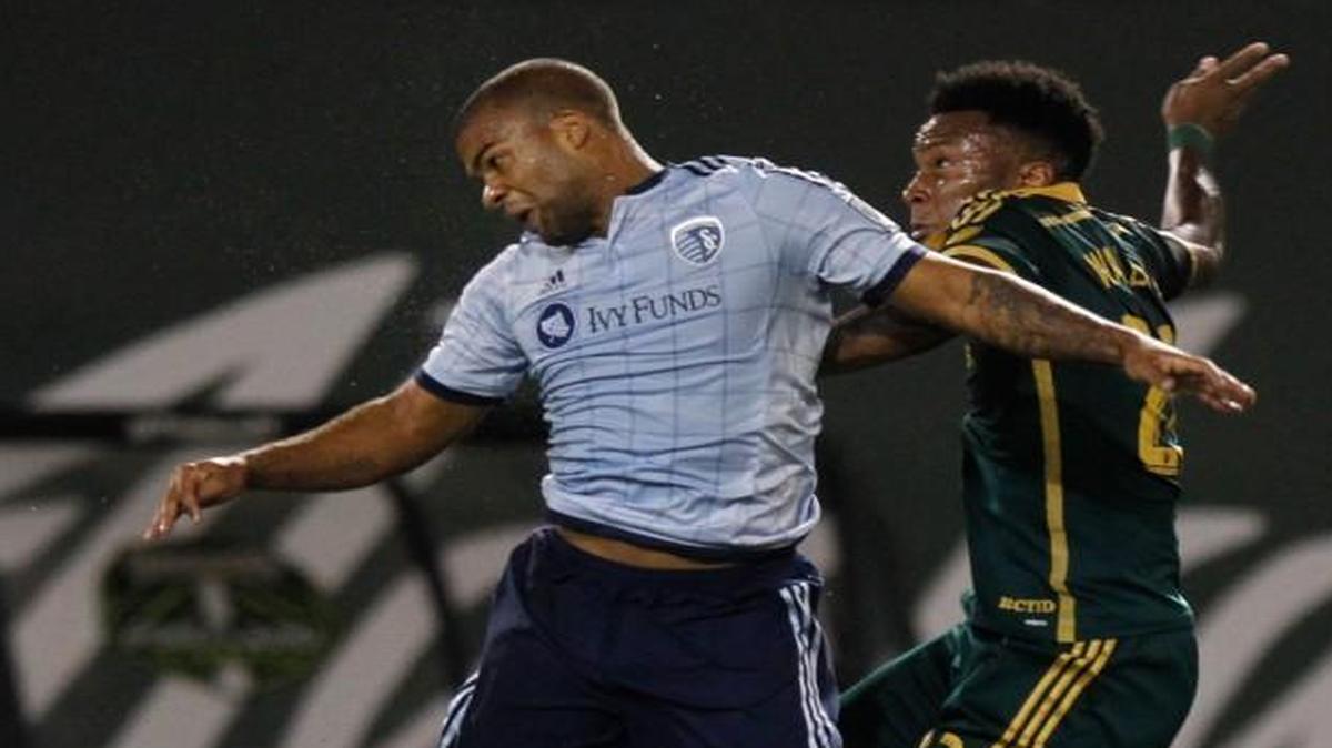 
Sporting KC defender Kevin Ellis headed the ball away from the Portland Timbers’ Rodney Wallace in the first half of Saturday’s match in Portland, Ore.
