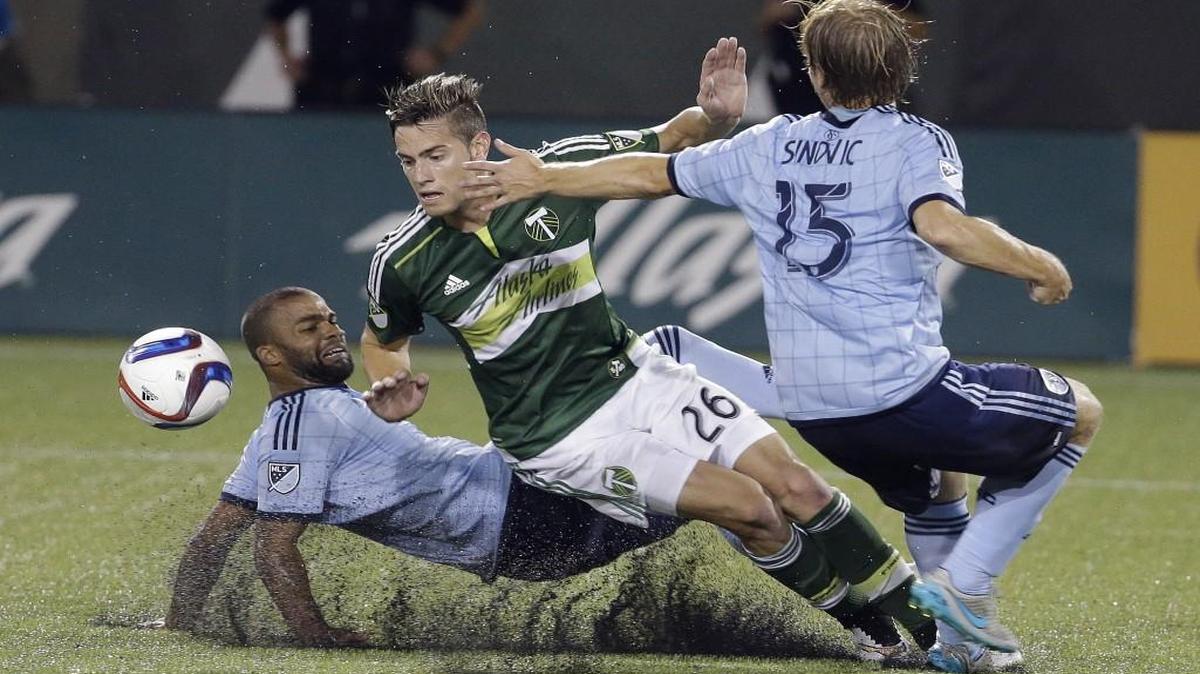 
Timbers forward Lucas Melano (center) fought for the ball with Sporting Kansas City’s Kevin Ellis (left) and Seth Sinovic during their soccer match earlier this month in Portland, Ore. Ellis admitted it is difficult to focus on the match with Seattle when Sporting will play a championship game Wednesday.
