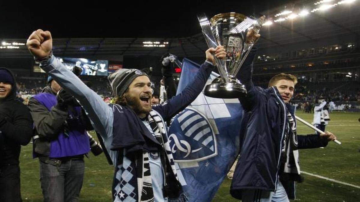 
Sporting Kansas City’s Graham Zusi, left, and Matt Besler, right, celebrated as they carried the MLS Cup after their 2-1 win over Real Salt Lake in the MLS Cup soccer final match in Kansas City, Kan., on Dec. 7, 2013.
