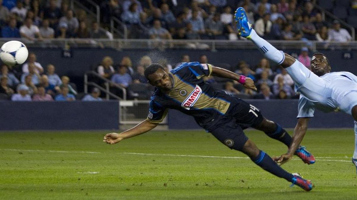 
Philadelphia Union midfielder Amobi Okugo flipped the ball away with his head as Sporting KC forward C.J. Sapong tried to get his foot on the ball during a game in 2012.
