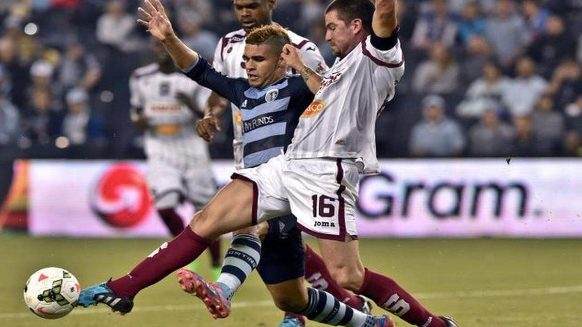 
Sporting KC forward Dom Dwyer (14) tries to keep control of the ball Deportivo Saprissa defender Gabriel Badilla (16) during the CONCACAF group stage soccer match against Deportivo Saprissa of Costa Rica on Thursday at Sporting Park.

