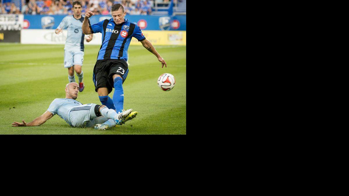 
Sporting Kansas City’s Aurelien Collin slid as he tried to block the pass to Montreal Impact’s Krzysztof Krol in the first half Saturday night in Montreal. Sporting won the match 2-1.
