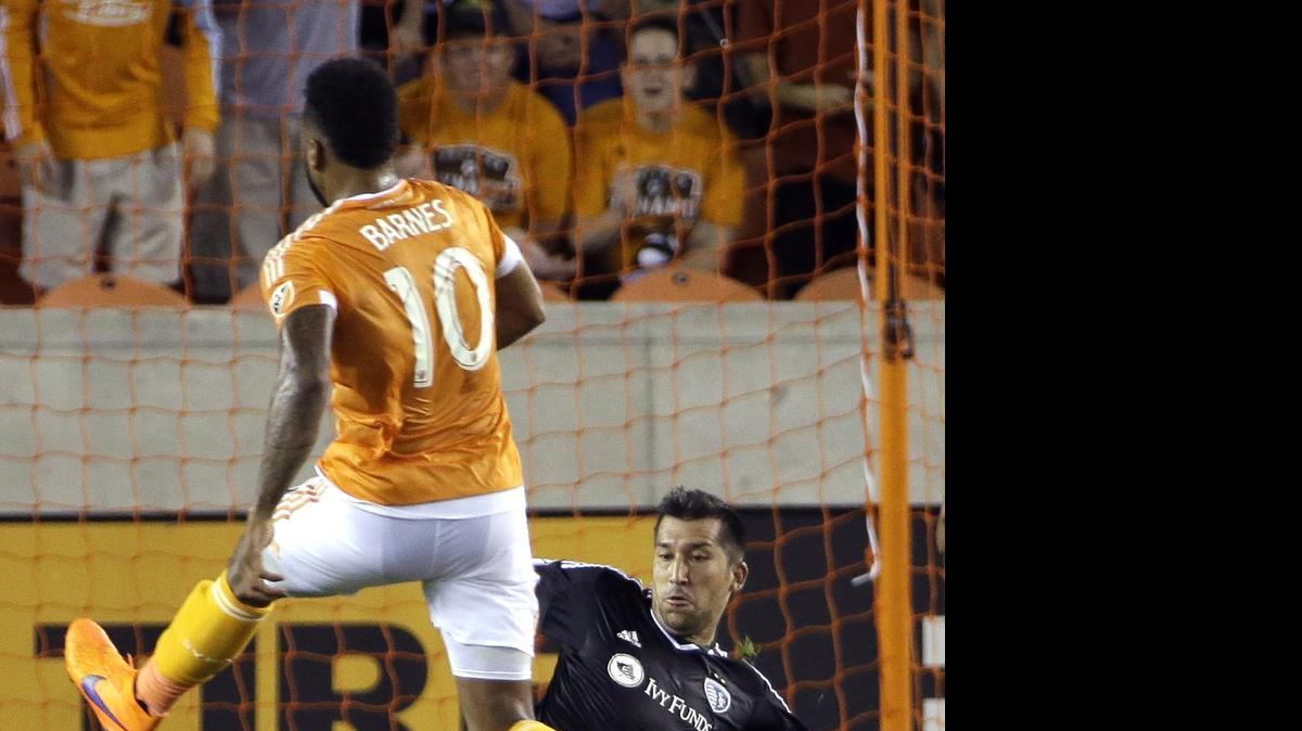 
Sporting Kansas City goalkeeper Luis Marin, right, kicks the ball away from Houston Dynamo's Giles Barnes (10) during the first half of an MLS soccer game Saturday, April 25, 2015, in Houston. 
