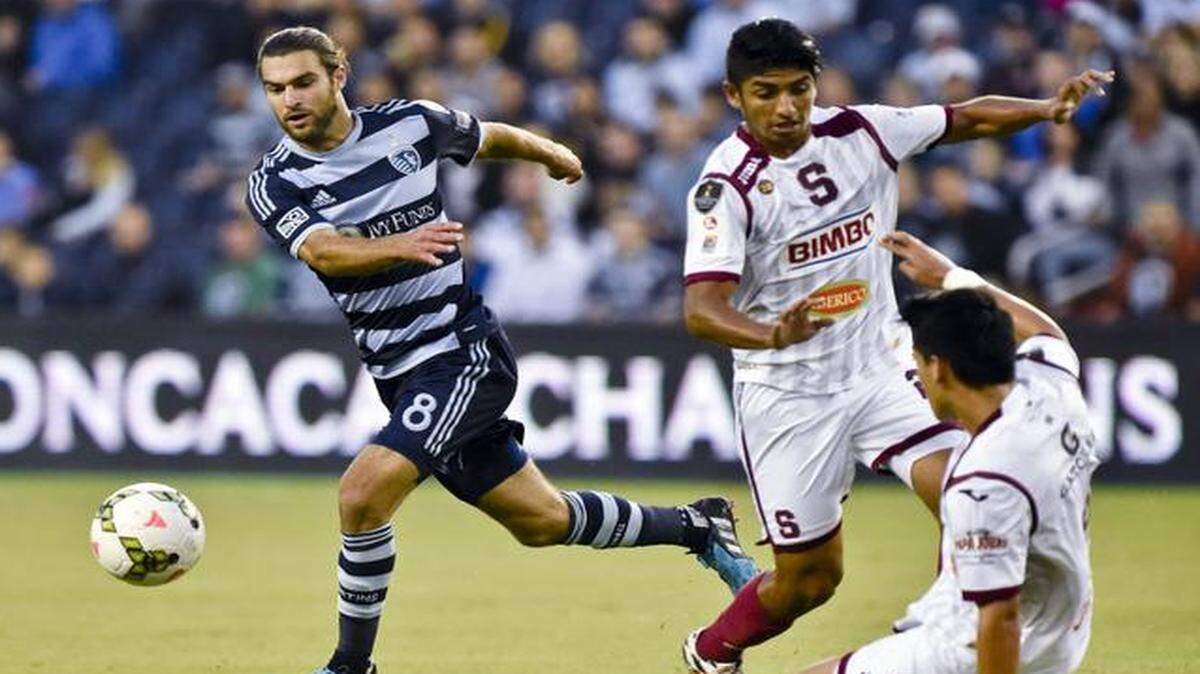 
Sporting KC midfielder Graham Zusi (8) kicks the ball away from the Deportivo Saprissa defense during Thursday’s CONCACAF soccer match at Sporting Park. Sporting KC won 3-1.
