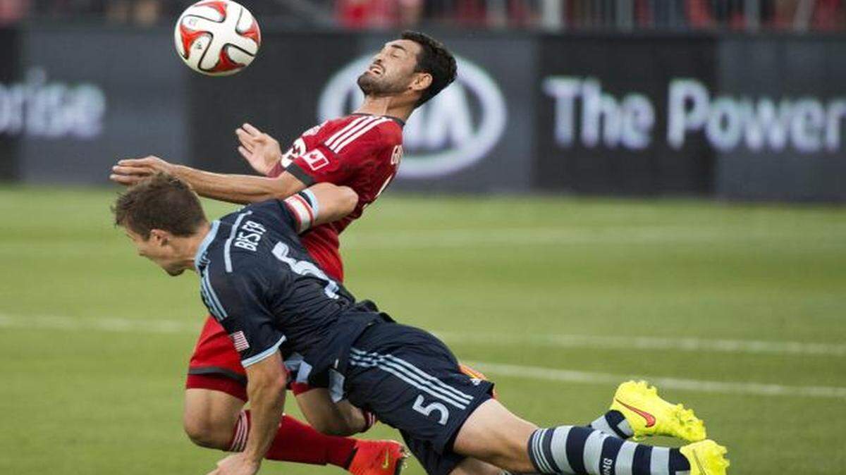 
Sporting Kansas City’s Matt Besler and Toronto FC forward Gilberto battled for a ball during Saturday’s game. Besler received two yellow cards and was ejected from the game.
