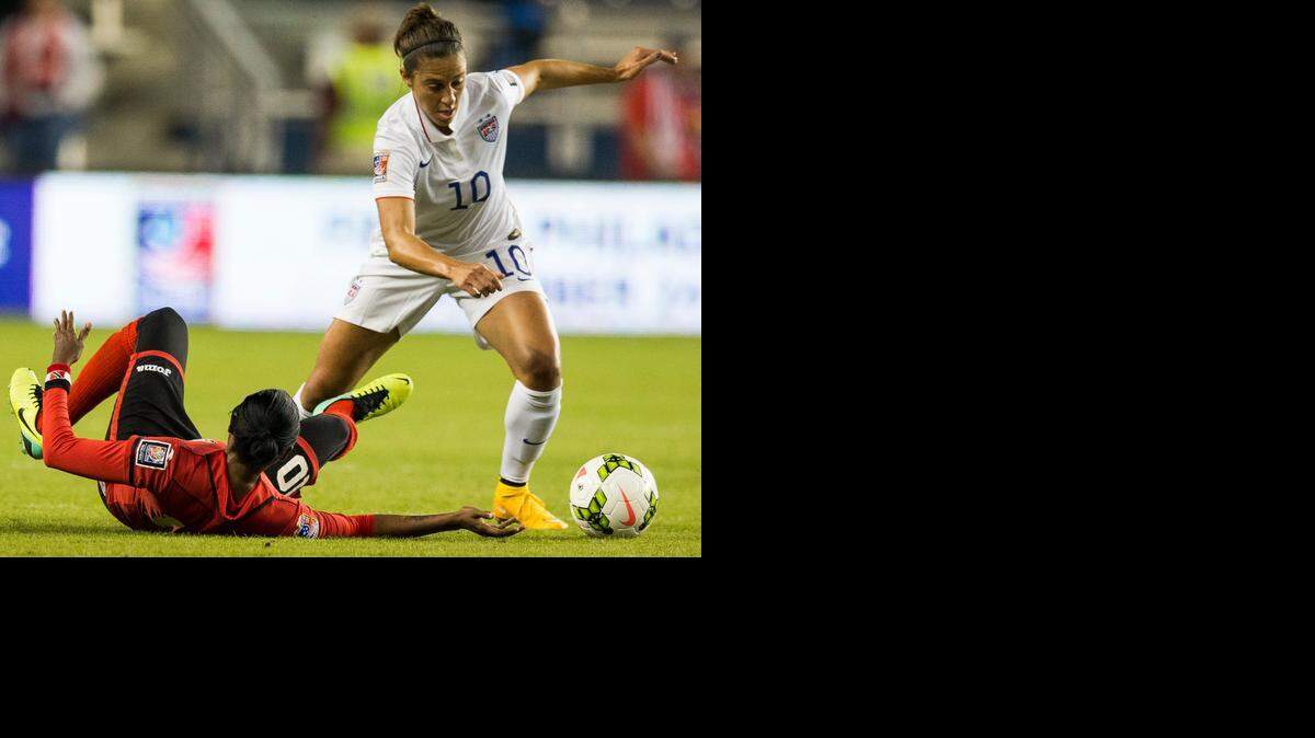 
American Carli Lloyd (right) controlled the ball against Tasha St Louis of Trinidad & Tobago in the CONCACAF Women's Championship.
