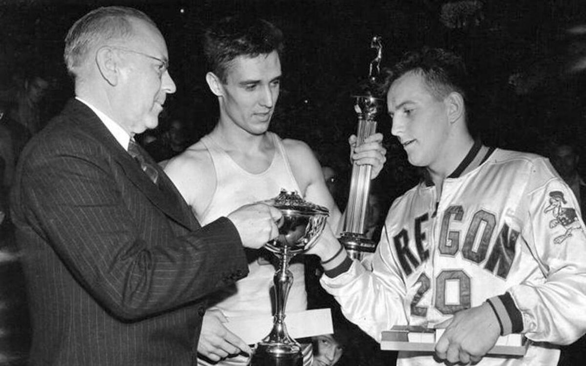 In this March 27, 1939 photo, provided by the University of Oregon Archives, Oregon's Bobby Anet (right) is presented the trophy by Big Ten Commissioner John Griffith (left) after Oregon defeated Ohio State 46-33 in the NCAA’s first tournament championship game in Evanston, Ill. Ohio State All-American Jimmy Hull (center) looks on. Oregon is playing in the Final Four once again this weekend.