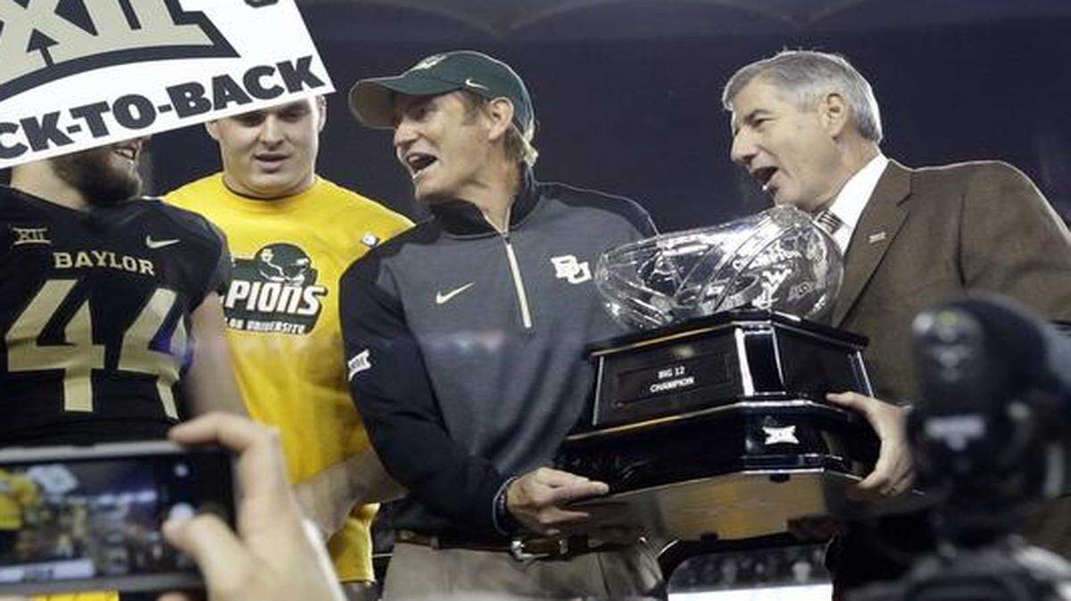 
Big 12 Commissioner Bob Bowlsby (right) presented Baylor head coach Art Briles (center) with the conference trophy after their 38-27 win over Kansas State on Saturday in Waco, Texas.

