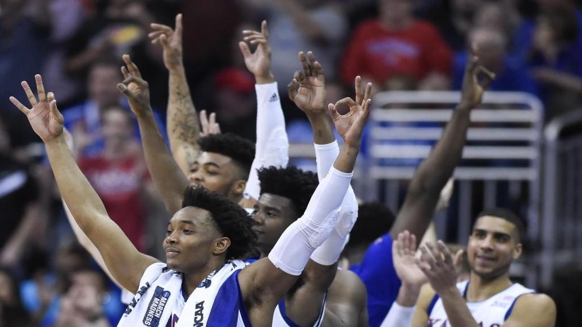 Kansas guard Devonte’ Graham (4) and the rest of the bench celebrated a three-pointer by Jayhawks forward Mitch Lightfoot (44) in the closing moments during KU’s 98-66 win Thursday in a Midwest Region semifinal at Sprint Center.