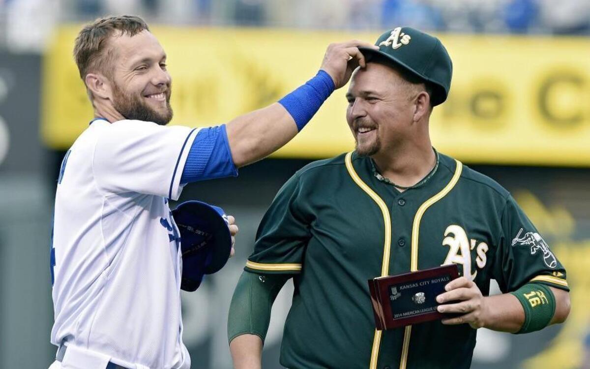 Kansas City Royals left fielder Alex Gordon put the hat back on Oakland Athletics designated hitter Billy Butler after Butler received his American League Championship ring before a game in 2015.