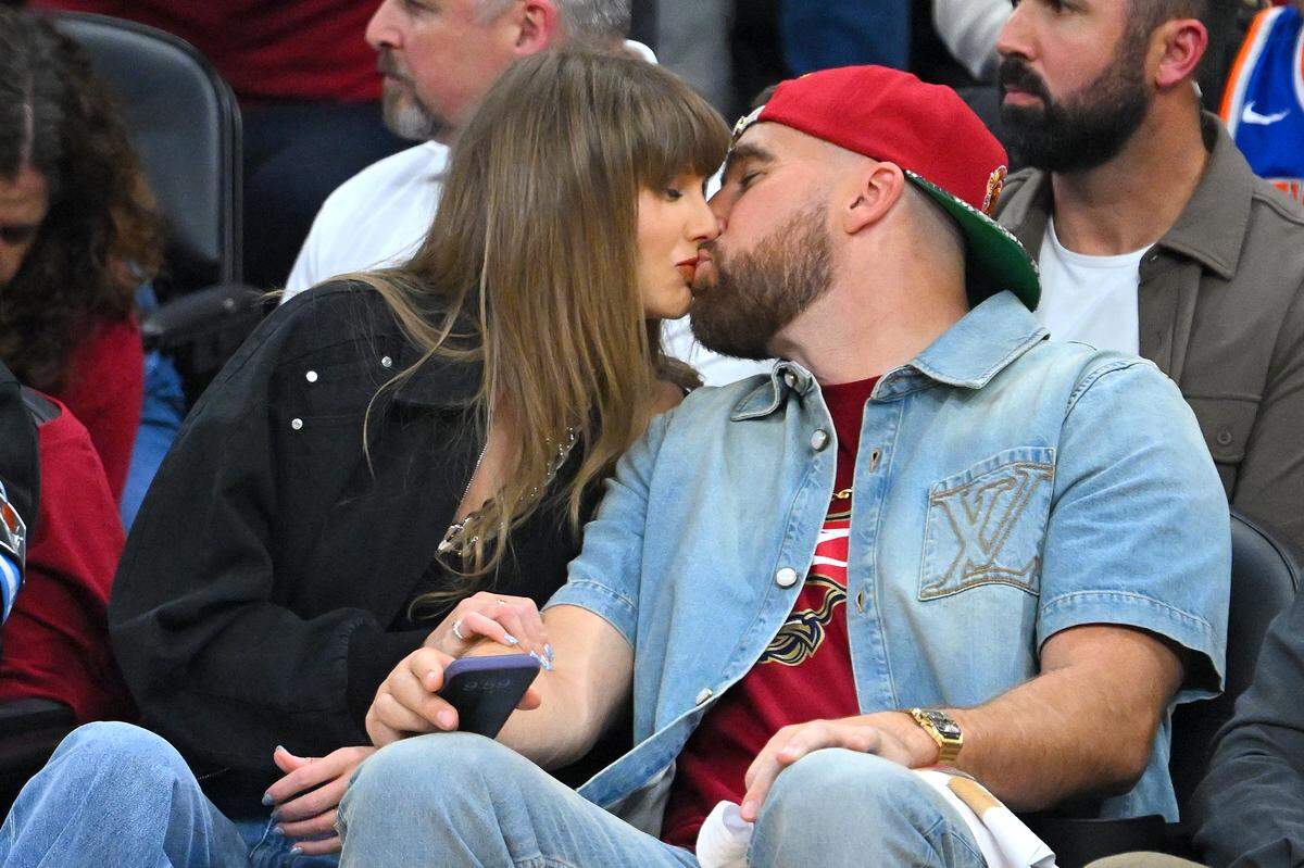 Singer Taylor Swift and Travis Kelce of the Kansas City Chiefs kiss during Game 3 between the New York Knicks and the Cleveland Cavaliers in the NBA Eastern Conference Finals at Rocket Arena on May 23, 2026 in Cleveland, Ohio.