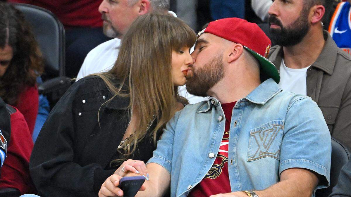 Singer Taylor Swift and Travis Kelce of the Kansas City Chiefs kiss during Game 3 between the New York Knicks and the Cleveland Cavaliers in the NBA Eastern Conference Finals at Rocket Arena on May 23, 2026 in Cleveland, Ohio.