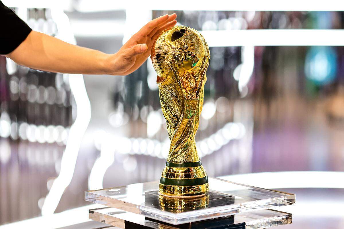 A visitor touches a model of the World Cup trophy ahead of a match between Argentina and Australia in 2023.