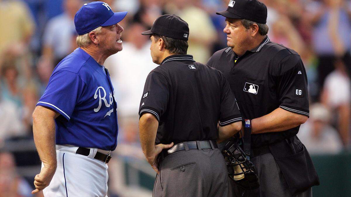Royals manager Buddy Bell argues with umpires Ed Rapuano #19 and Joe West #22 in the 8th inning of the game against the Los Angeles Angels of Anaheim on July 22, 2006 at Kauffman Stadium in Kansas City, Missouri.