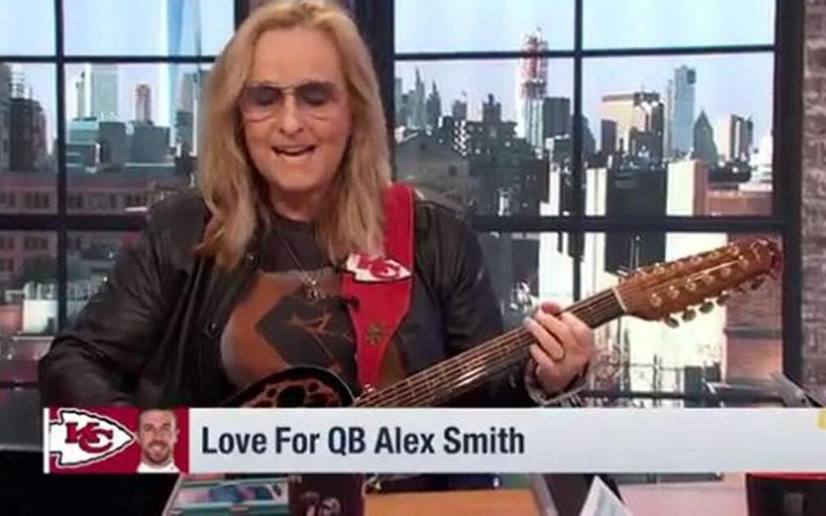 Take note of the guitar strap on Melissa Etheridge’s guitar.